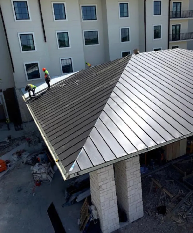 Crew installing standing seam metal roof panels on a commercial project in Scotts Valley